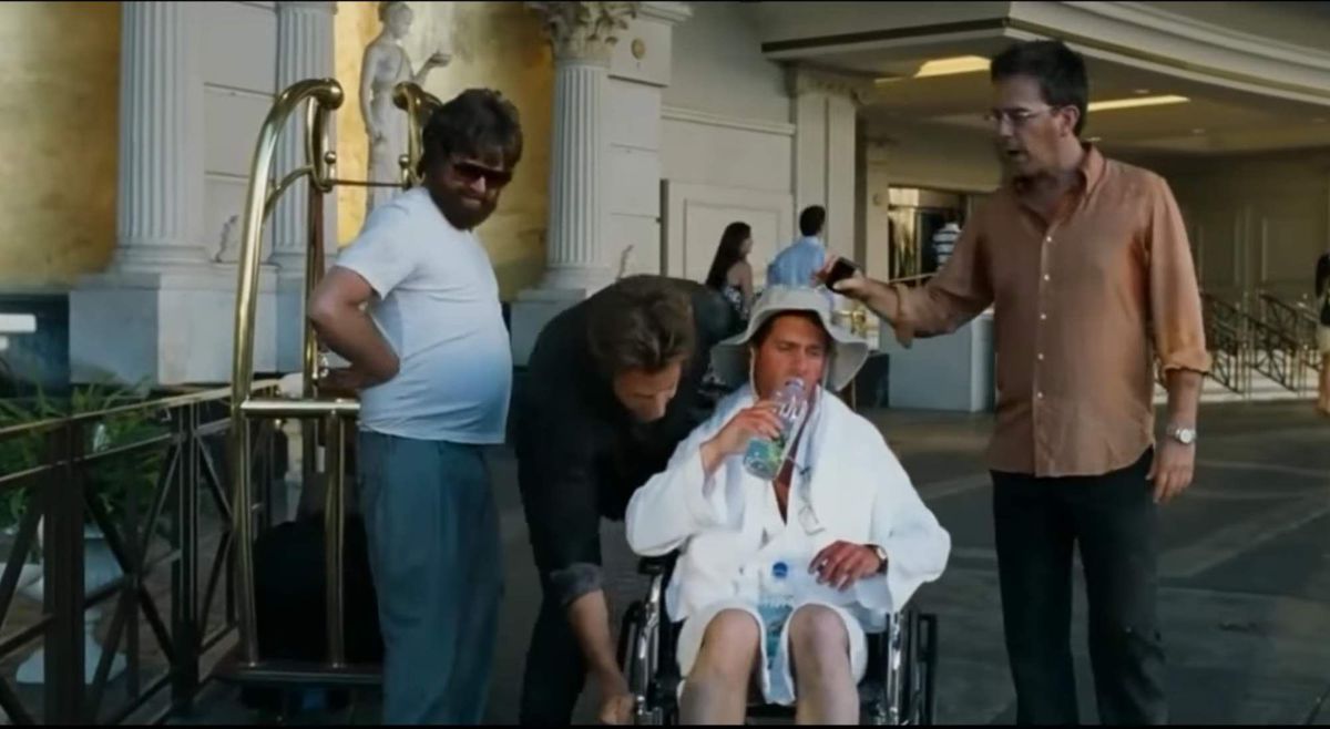 Doug, totally burnt and sitting in a wheelchair, in the Hangover while everyone crowds around