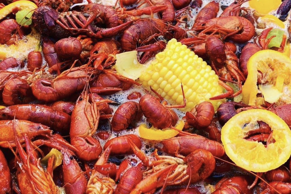 A crawfish boil with corn, lemon slices, sausage, and potatoes