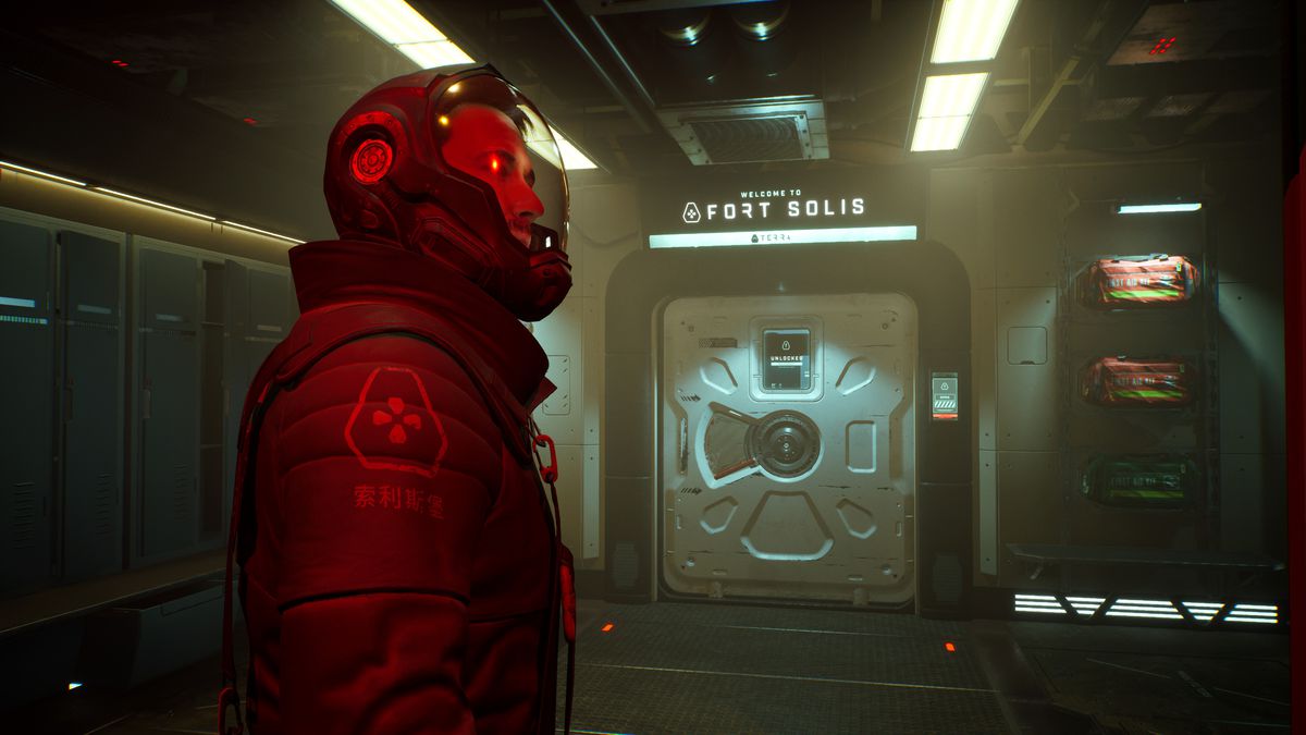 The side profile of someone in a space suit in Fort Solis. They are standing in front of a door that reads “Welcome to Fort Solis.”