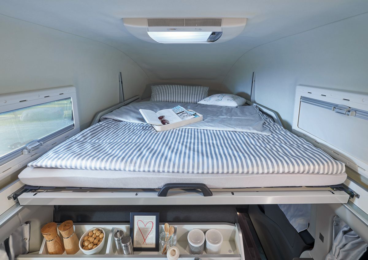 An upper sleeping area in a small mini van camper van. 