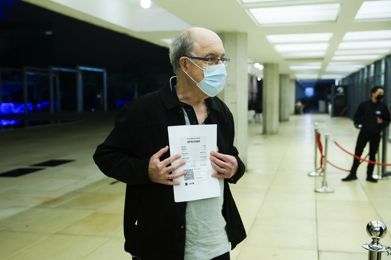 A man presents a Green Pass before entering a musical performance in Tel Aviv, Israel.