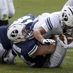 Brigham Young Cougars running back Trey Dye, right, is tackled by defensive end Zayne Anderson, left, during a spring football scrimmage at LaVell Edwards Stadium in Provo, Saturday, March 26, 2016.