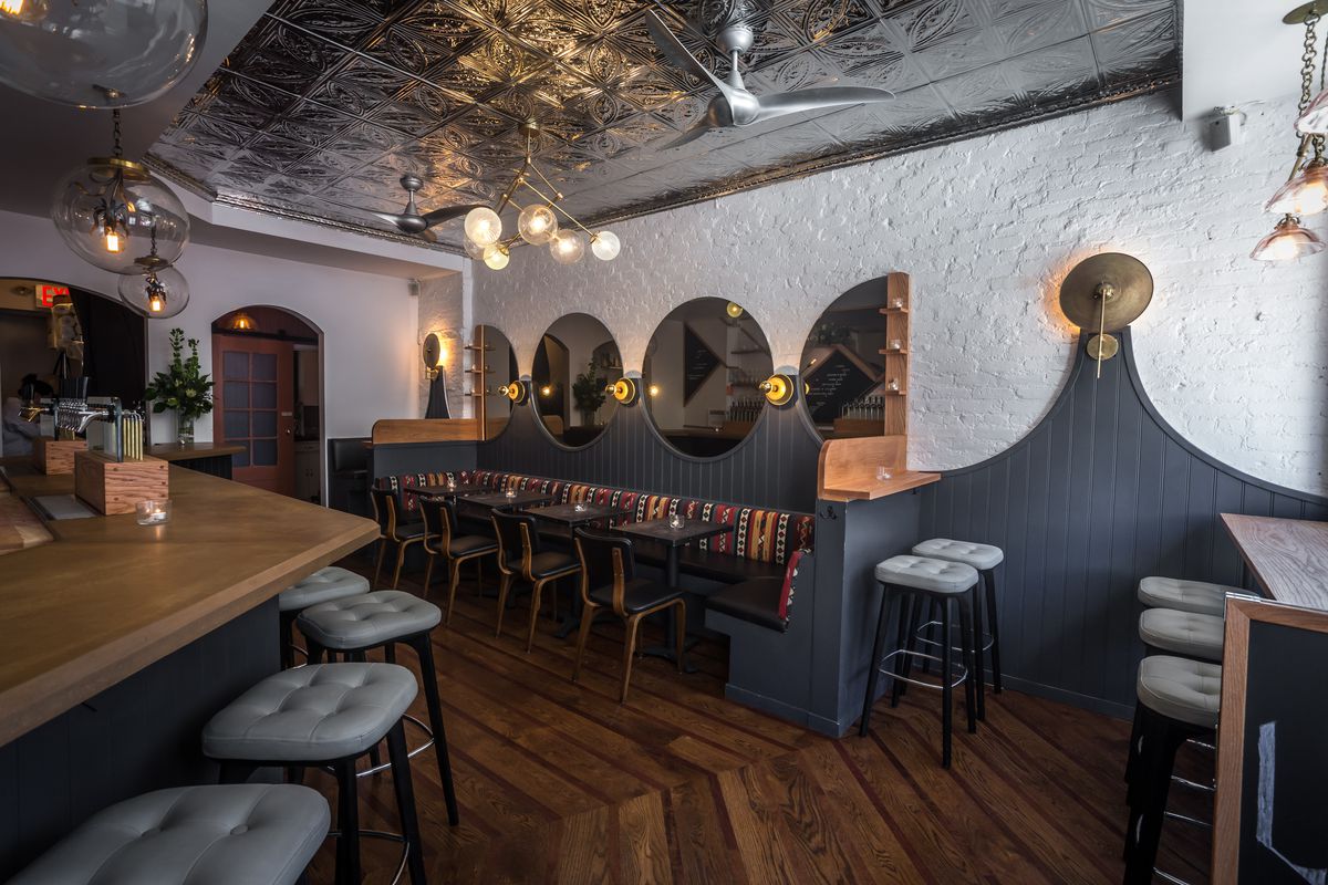 The interior of the rustic wine bar Lois with exposed white break and leather benches