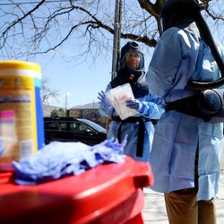 Lee Cherie Booth and Travis K. Langston, both nurses with the Salt Lake County Health Department, wait for their next appointment to arrive for a COVID-19 test outside of the Salt Lake City Public Health Center on Friday, April 10, 2020.