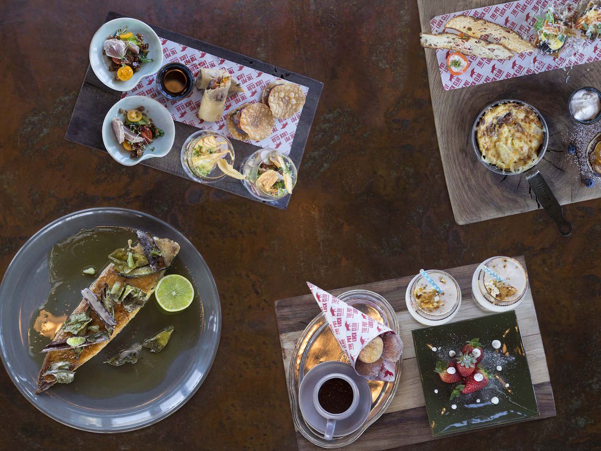 A top-down view of a spread of dishes arrange on various boards and bowls