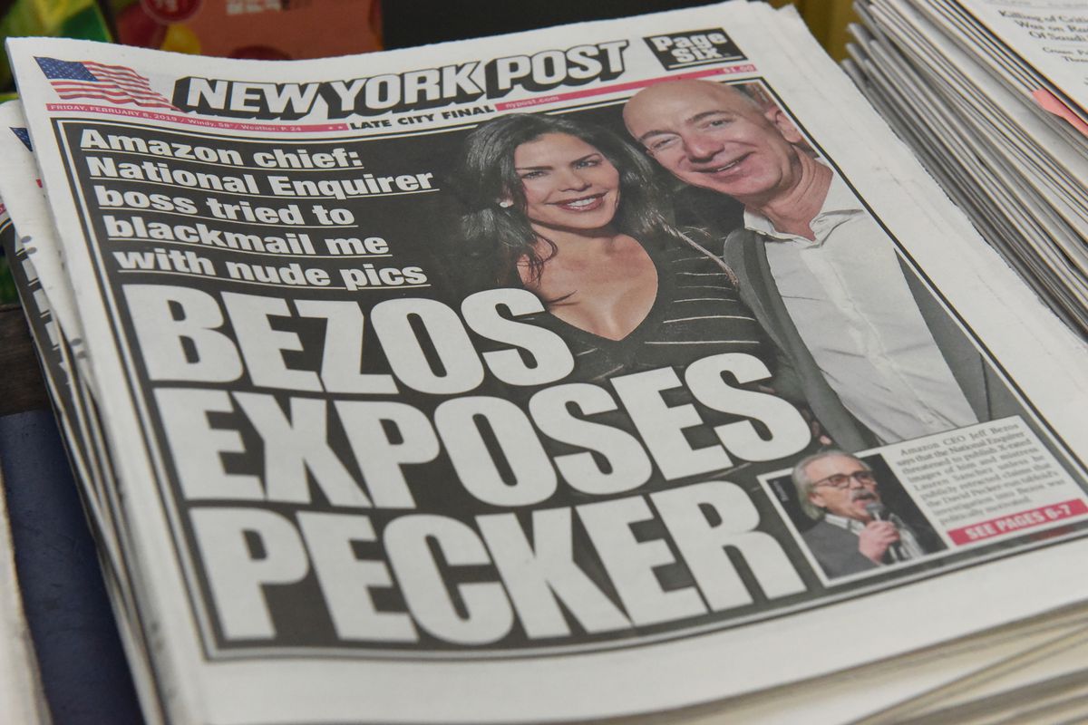 A picture of a National Enquirer tabloid paper with a picture of Jeff Bezos and Laura Sanchez and the headline “Bezos Exposes Pecker.”