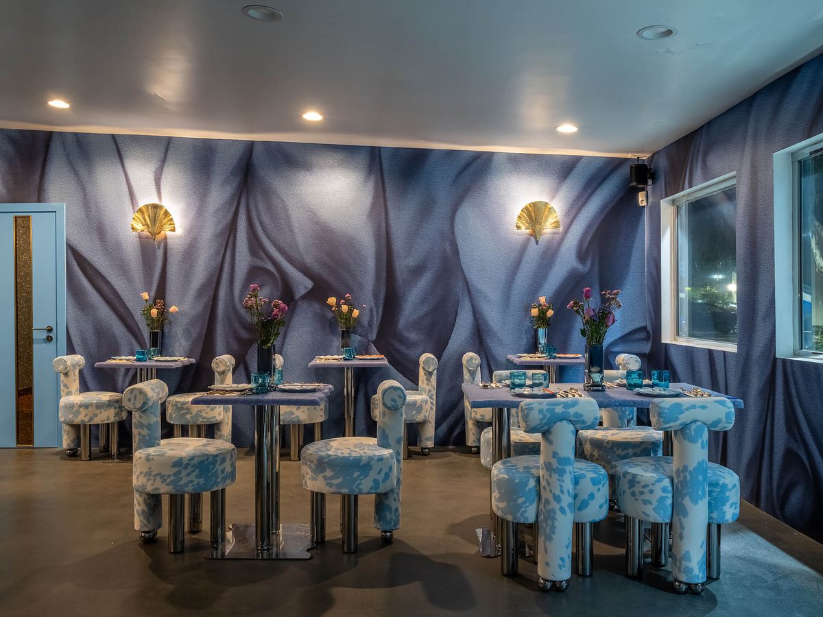 The light blues and purples of a very design-heavy new restaurant with rounded seats.