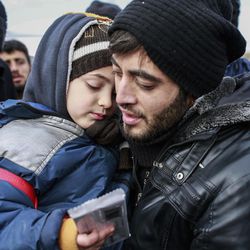 Muhammed Salih, 26, from Aleppo, Syria, holds his son, name not given, after crossing into Turkey, at the Cilvegozu border gate with Syria, near Hatay, southeastern Turkey, Sunday, Dec, 18, 2016. Several people were able to cross into Turkey after they managed to leave the embattled Syrian city. The Aleppo evacuation was suspended Friday after a report of shooting at a crossing point into the enclave by both sides of the conflict. 
