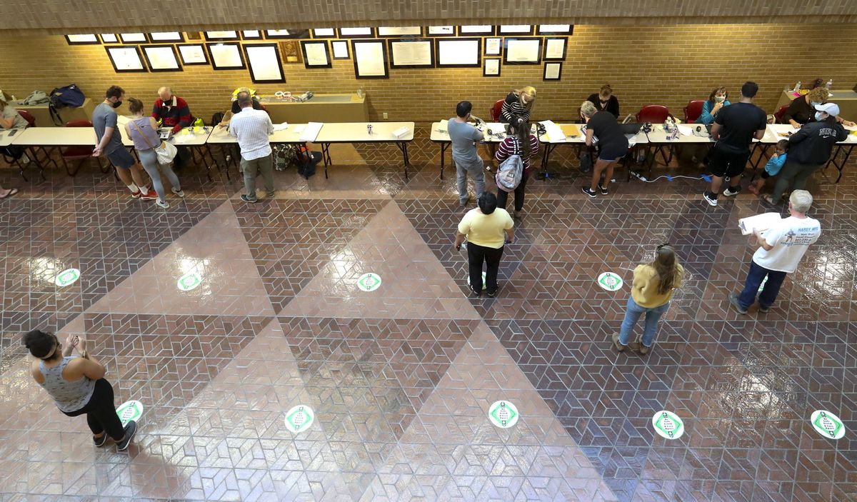 Citizens check in and register to vote in person at the Salt Lake County Government Center during the first day of early voting in Utah on Tuesday, Oct. 20, 2020.