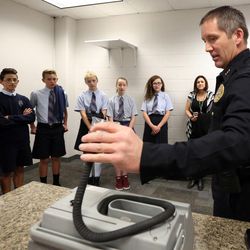 Bountiful Assistant Police Chief Ed Biehler shows eighth-graders from St. Olaf Catholic School a breathalyzer while giving the students a tour of the police station in Bountiful on Wednesday, Nov. 16, 2016. Members of the student body paid to wear casual clothing to school instead of their uniforms and donated the $865.36 they raised to the Bountiful Police Department.