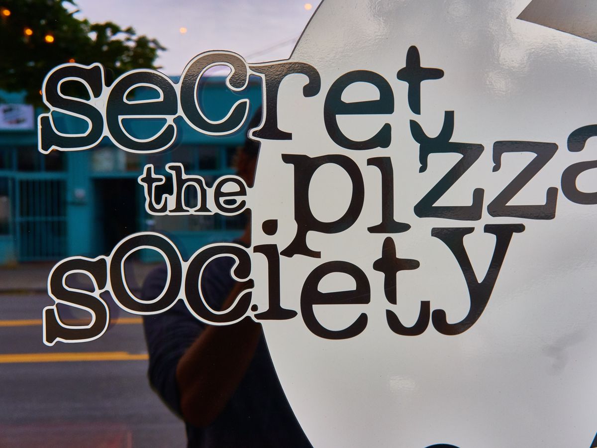 A window sign for the Secret Pizza Society.