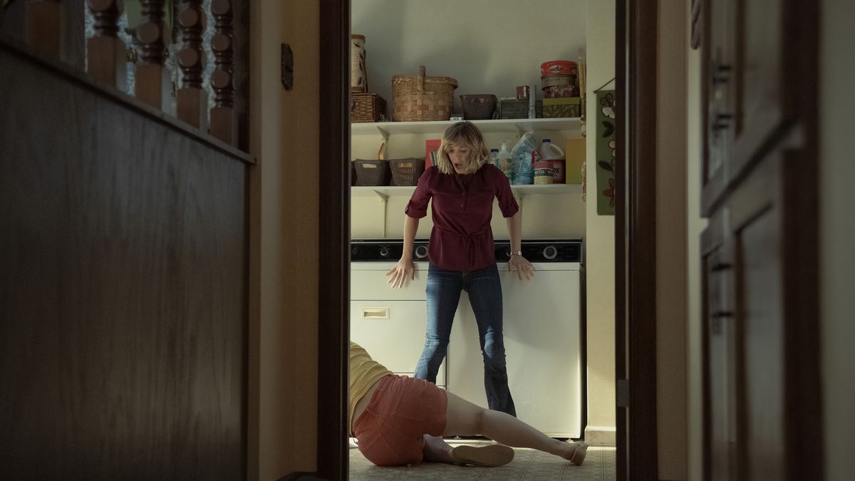 Candy (Elizabeth Olson) looks startled at Betty (Lily Rabe) on the ground, as shot through a doorway, in a still from Love &amp; Death on HBO