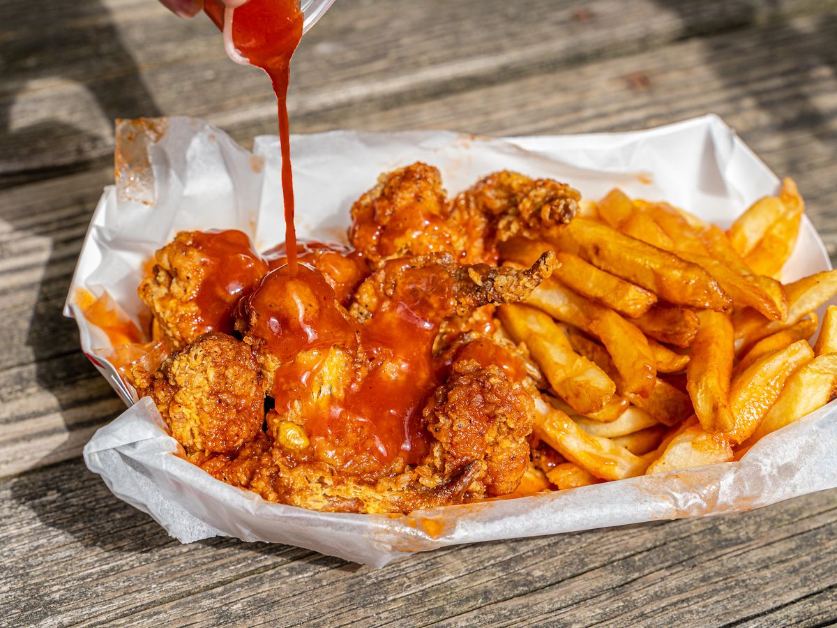 A basket of fried chicken with mild sauce.