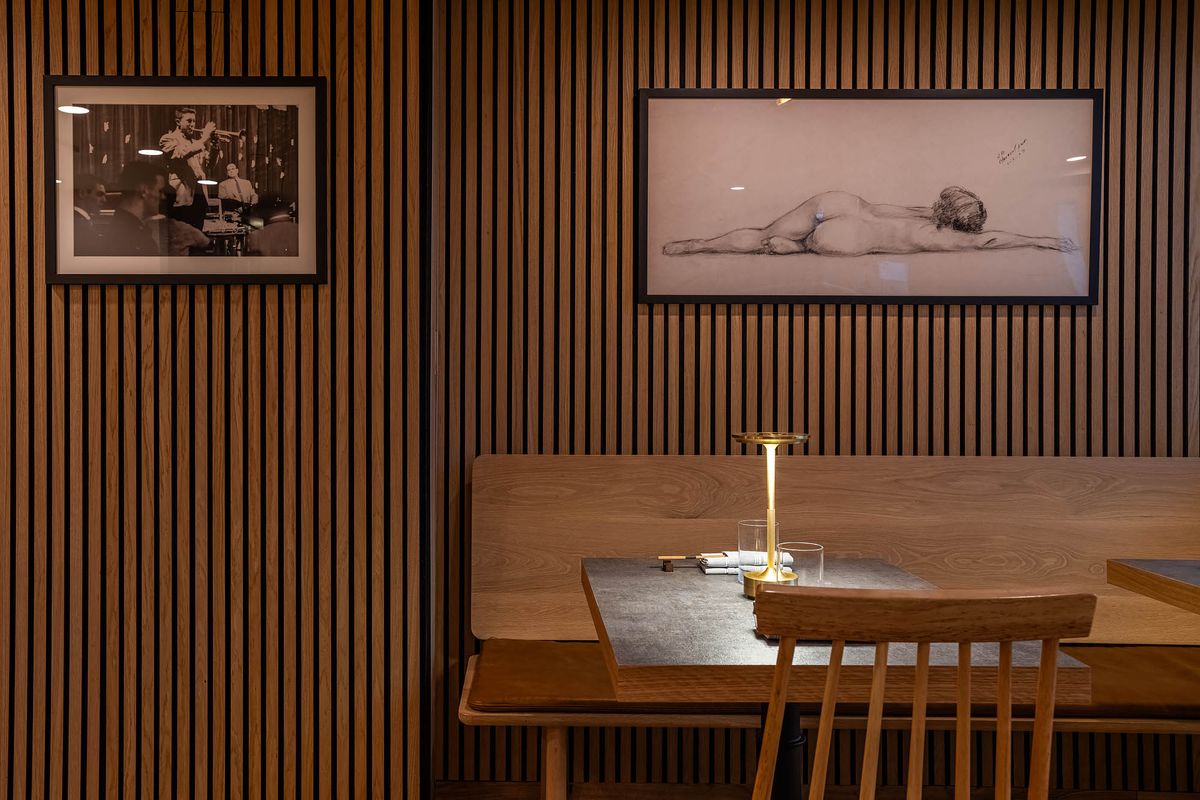 A black and white photo and simple nude sketch adorn the minimalist-designed dining room of Sushi Note Omakase.
