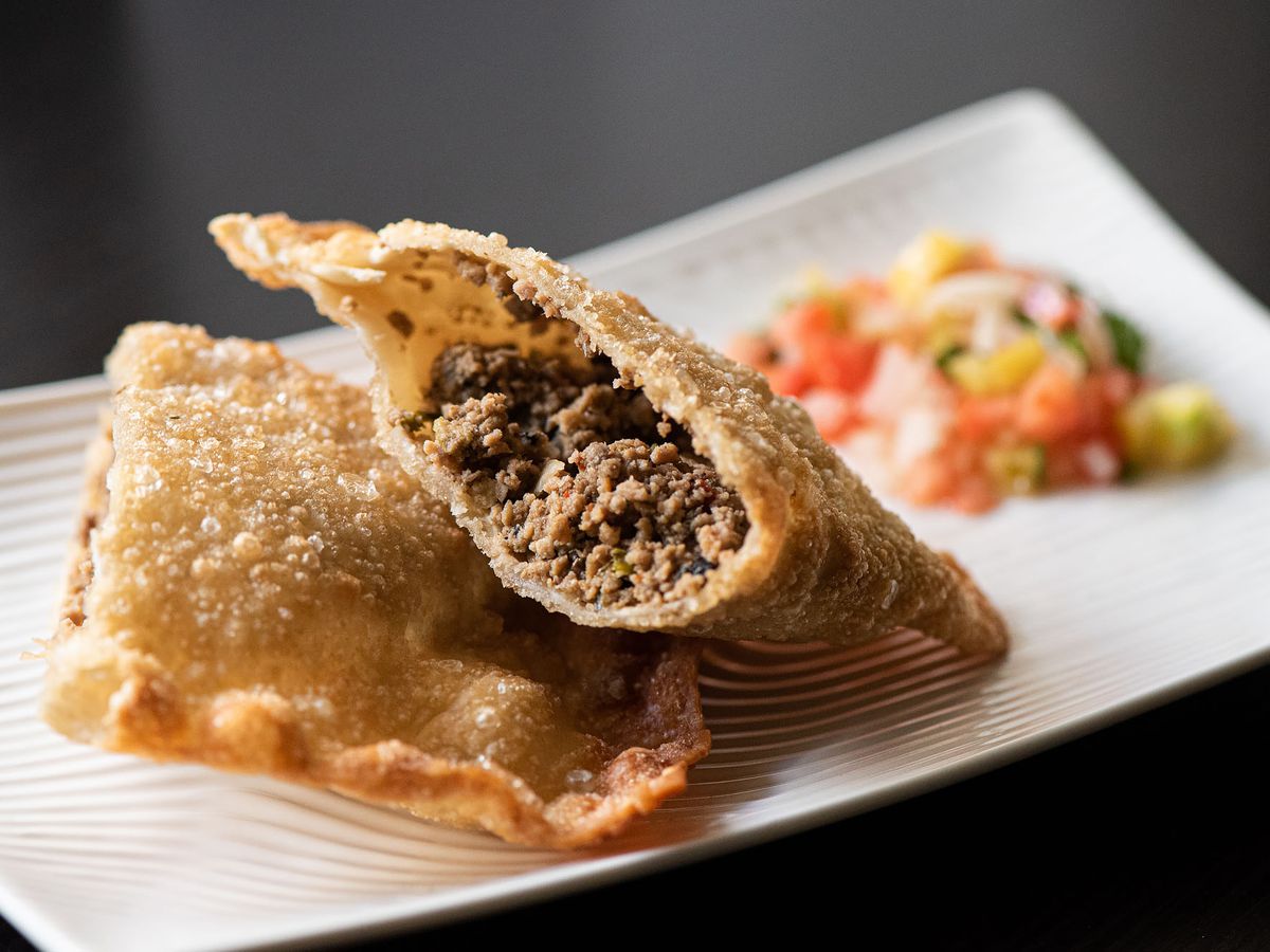 Brazilian fried pasties with meat filling on a white plate.