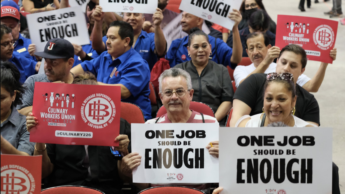 Members of the Las Vegas Culinary Union hold up protest signs.