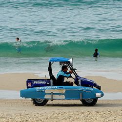 A lifeguard patrols Sydney's Bondi Beach as swimmers venture back into the water even though the beach was declared closed due to a tsunami threat on Sunday.