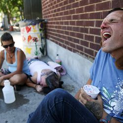 Xander Larucci, right, whose nose is bloody from being beaten up earlier in the day, experiences a tick he said is due to Tourette's syndrome while sitting near the The Road Home shelter on Rio Grande Street in Salt Lake City on Wednesday, June 22, 2016. At left, Laura Day tends to her friend Drea Westerfield, an alcoholic who had passed out from drinking.