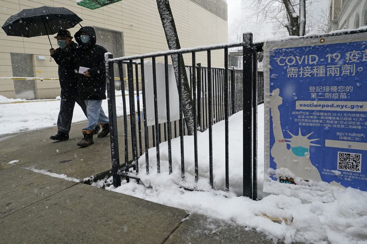 In this Feb. 7, 2021, file photo, two people enter a New York City vaccine hub during a snowstorm in New York.