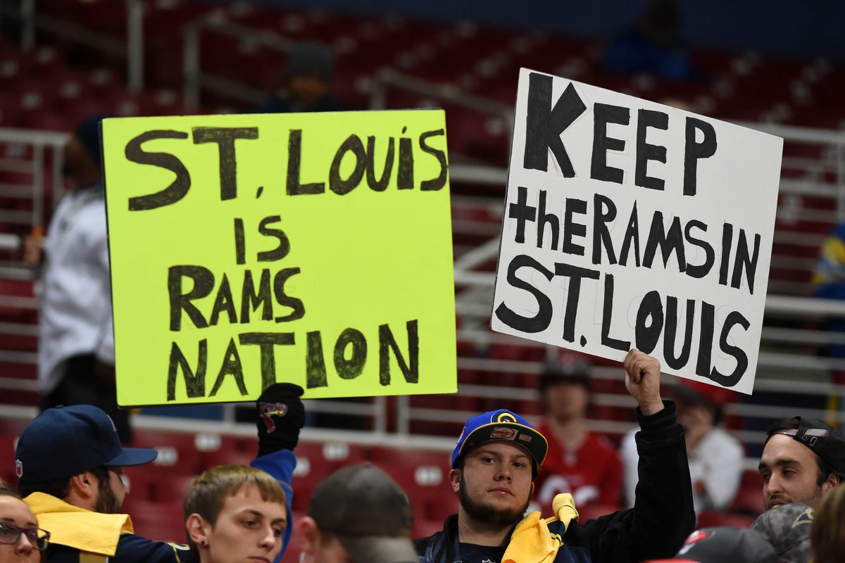 St. Louis Rams fans hold signs that read "St. Louis is Rams Nation" and "Keep Rams in St. Louis"