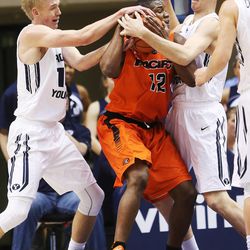 Brigham Young Cougars forward Ryan Andrus (10) and Brigham Young Cougars forward Isaac Neilson (35) defend Pacific Tigers forward Eric Thompson (12) at the Marriott Center Saturday, Feb. 14, 2015. BYU beat the Tigers, 84-59.