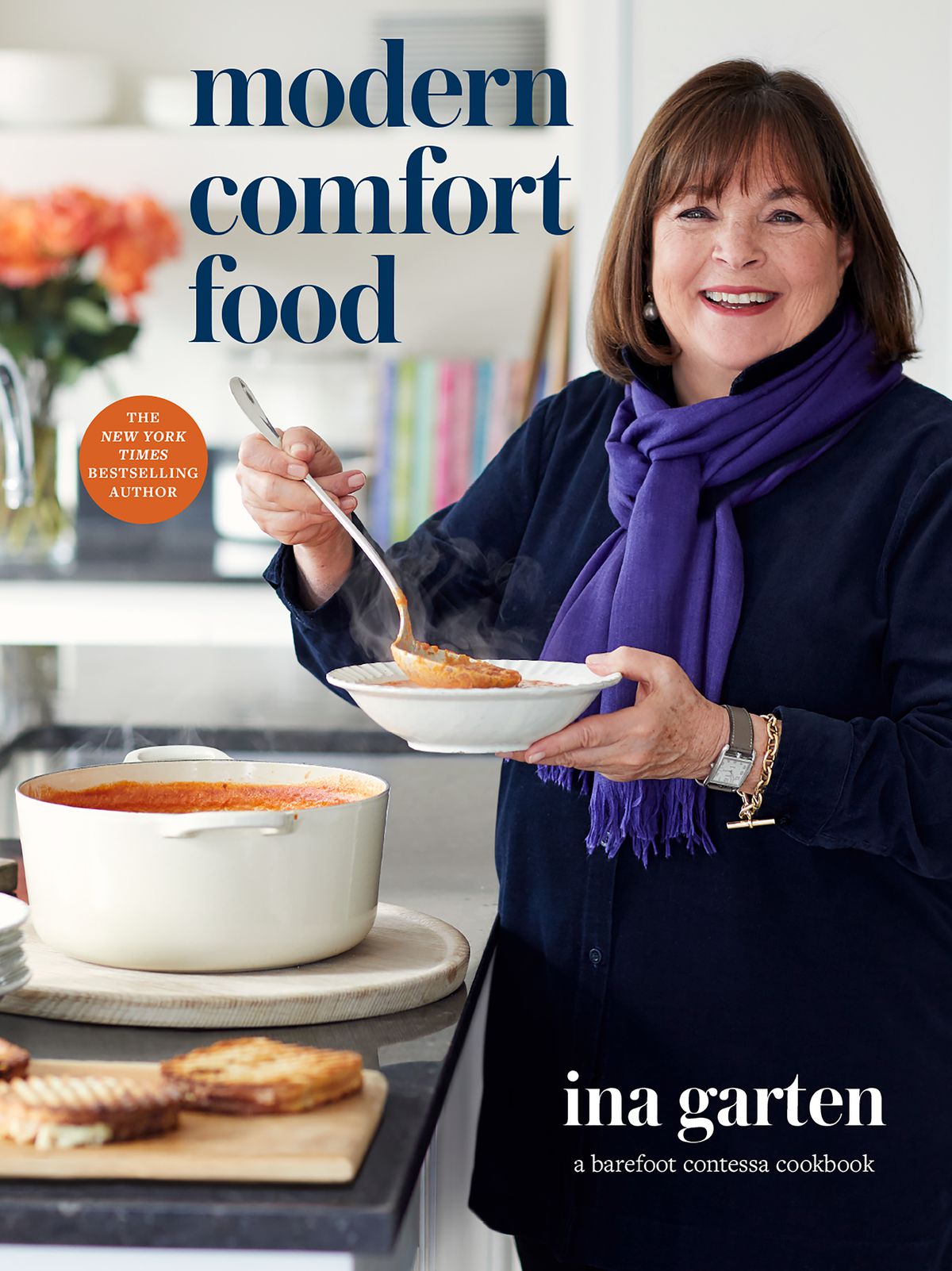 Ina Garten holding a bowl of soup and wearing a purple scarf on the cookbook cover for Modern Comfort Food