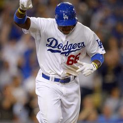 Los Angeles Dodgers' Yasiel Puig gestures as he hits an RBI single during the eighth inning of their baseball game against the San Francisco Giants, Monday, June 24, 2013, in Los Angeles.  