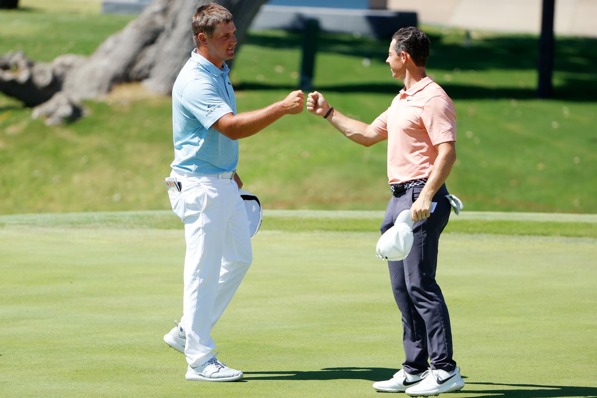 Bryson DeChambeau of the United States and Rory McIlroy of Northern Ireland bump fists after finishing on the 18th green during the final round of the Charles Schwab Challenge on June 14, 2020 at Colonial Country Club in Fort Worth, Texas.