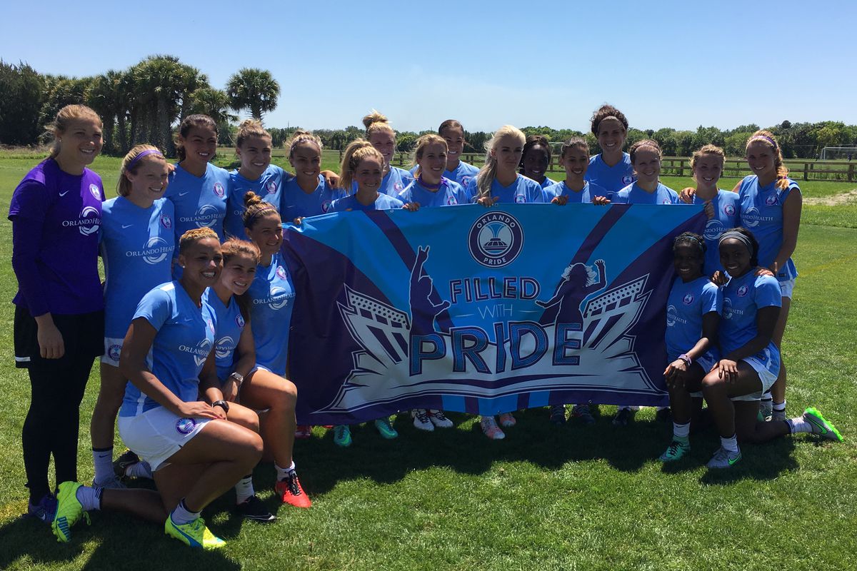 Becky Edwards holding the #FilledWithPride banner left of Kaylyn Kyle front row.