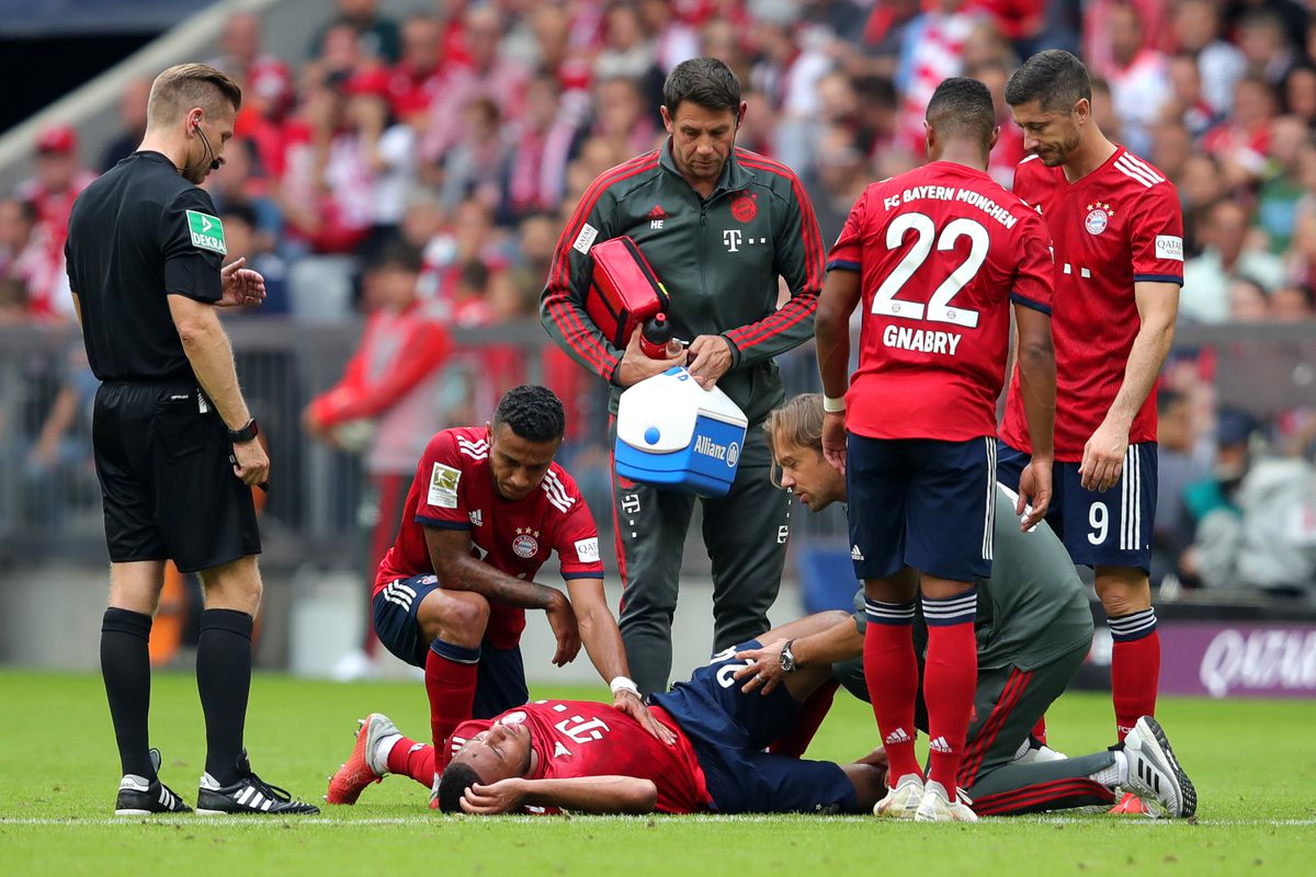 MUNICH, GERMANY - SEPTEMBER 15: Corentin Tolisso of Bayern Munich goes down injured during the Bundesliga match between FC Bayern Muenchen and Bayer 04 Leverkusen at Allianz Arena on September 15, 2018 in Munich, Germany. 