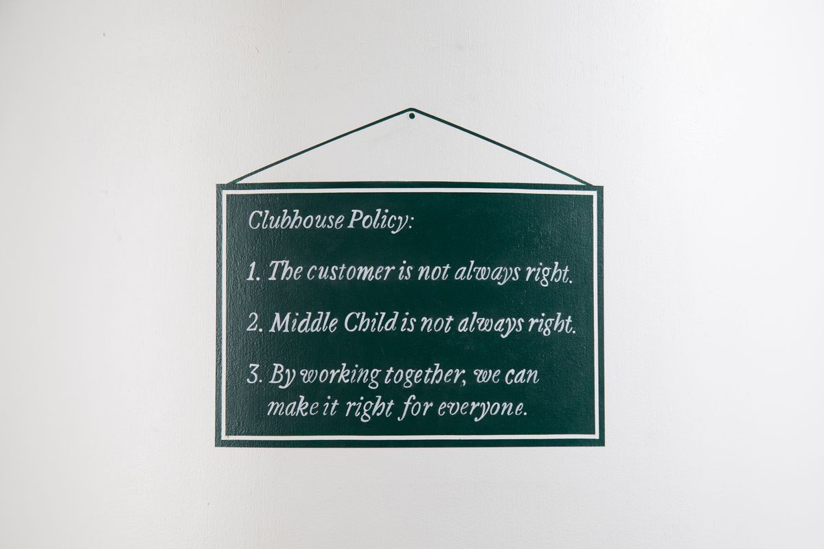A painted sign that reads, “Clubhouse policy: the customer is not always right, Middle Child is not always right, by working together we can make it right for everyone.”