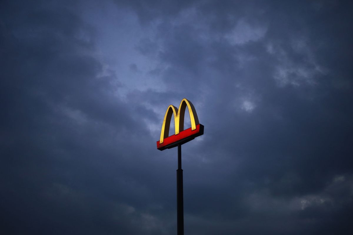 The McDonald’s arches logo alone against a dark and cloudy sky.