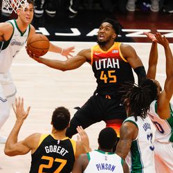 Utah Jazz guard Donovan Mitchell, center, attempts to score past Dallas Mavericks defenders during an NBA game at Vivint Arena in Salt Lake City on Saturday, Dec. 25, 2021.