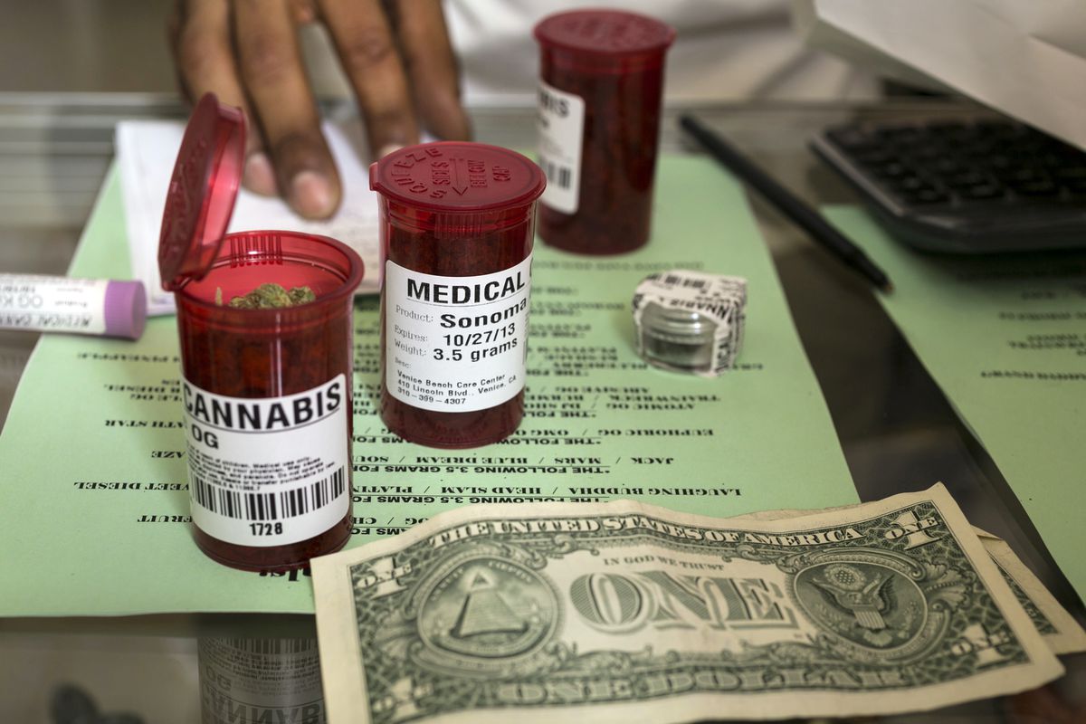FILE - In this May 14, 2013, file photo, medical marijuana prescription vials are filled at a medical marijuana dispensary in the Venice Beach area of Los Angeles. California would likely lose money and face insurmountable federal hurdles if it tried to c
