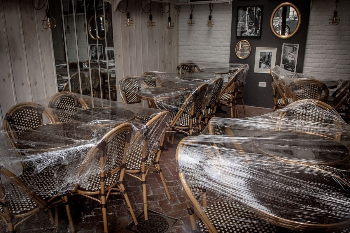Patio chairs and tables covered in plastic wrap.