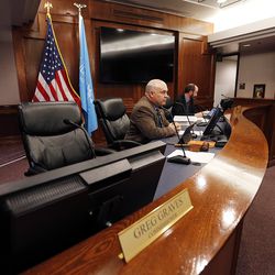 Utah County Commissioner Greg Graves' chair is empty in the foreground as he participates by phone during commission meeting in Provo on Tuesday, Dec. 12, 2017. Commissioners Bill Lee, center, and Nathan Ivie participate.