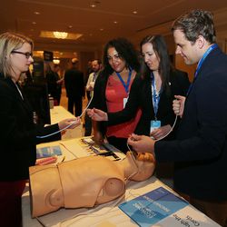 Mackenzie Hales, left, and Benjamin Fogg, right, of Through the Cords, show Alicia Ryans, second from left, and Ariel Briggs how to use a color-coded steerable introducer and breathing tube during the Governor's Utah Economic Summit in Salt Lake City on Friday, April 15, 2016. The aim is to make intubation safer for patients and more streamlined for professionals.