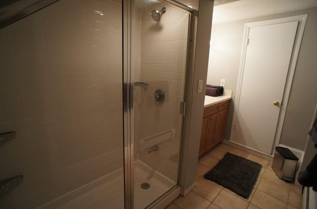 A bathroom with a sliding plastic door on the shower.