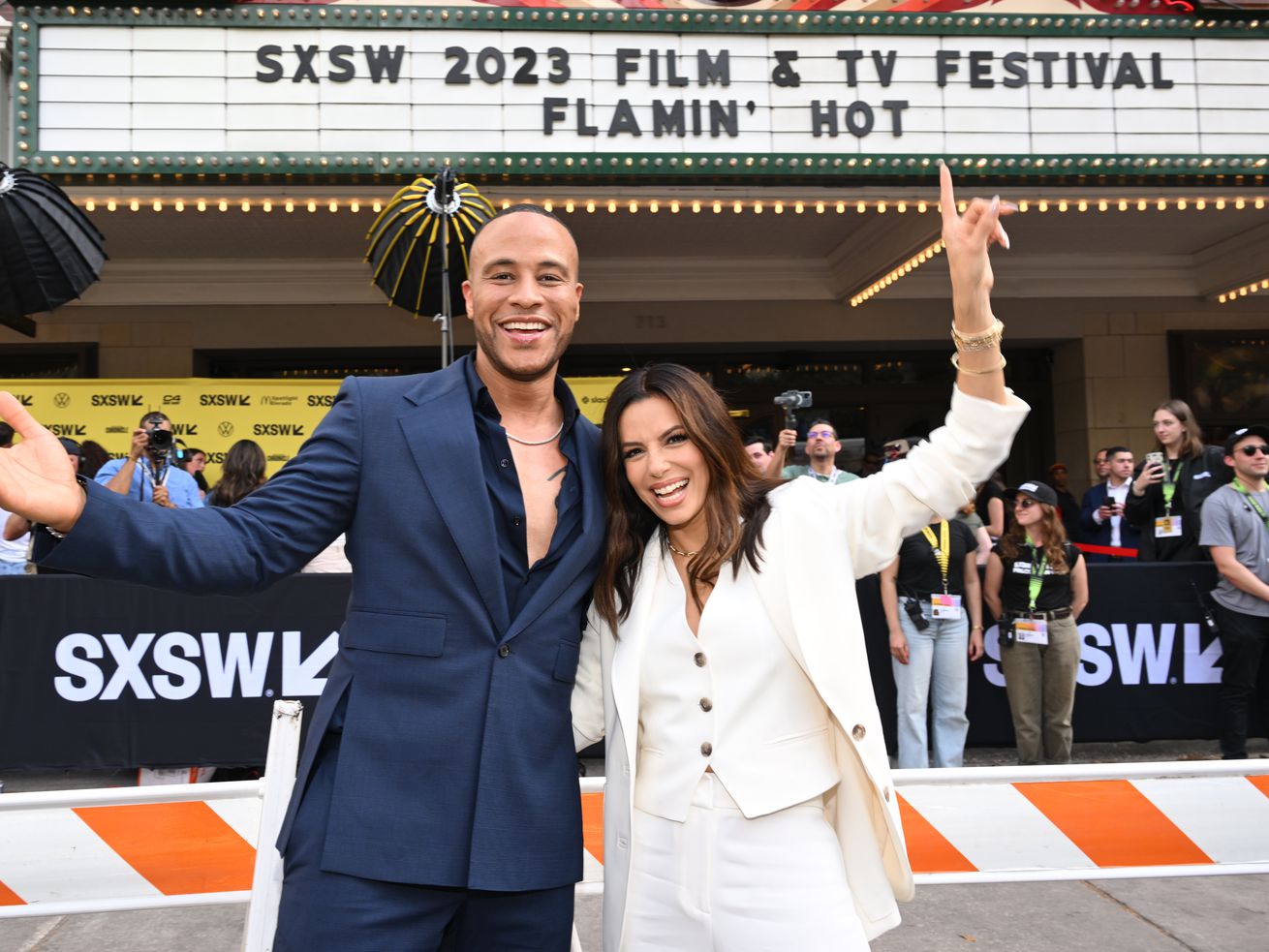 Two people standing in front of a movie theater marquee with the sign reading “SXSW 2023 Film &amp; TV Festival Flamin’ Hot.”