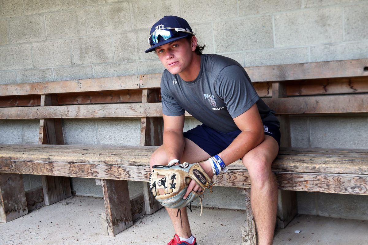 Quinn McDaniel sitting on a bench with his glove