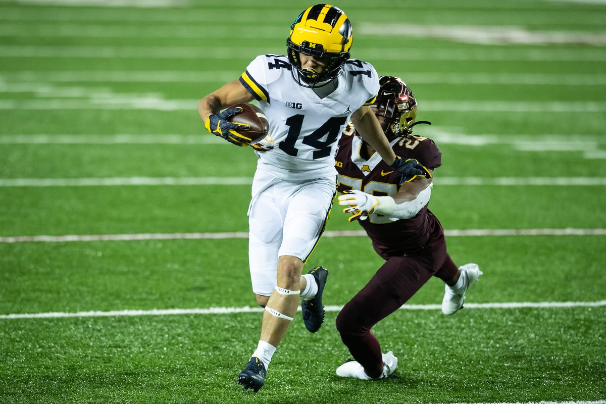 Roman Wilson of the Michigan Wolverines carries the ball past Jordan Howden of the Minnesota Golden Gophers in the third quarter of the game at TCF Bank Stadium on October 24, 2020 in Minneapolis, Minnesota. The Wolverines defeated the Gophers 49-24.