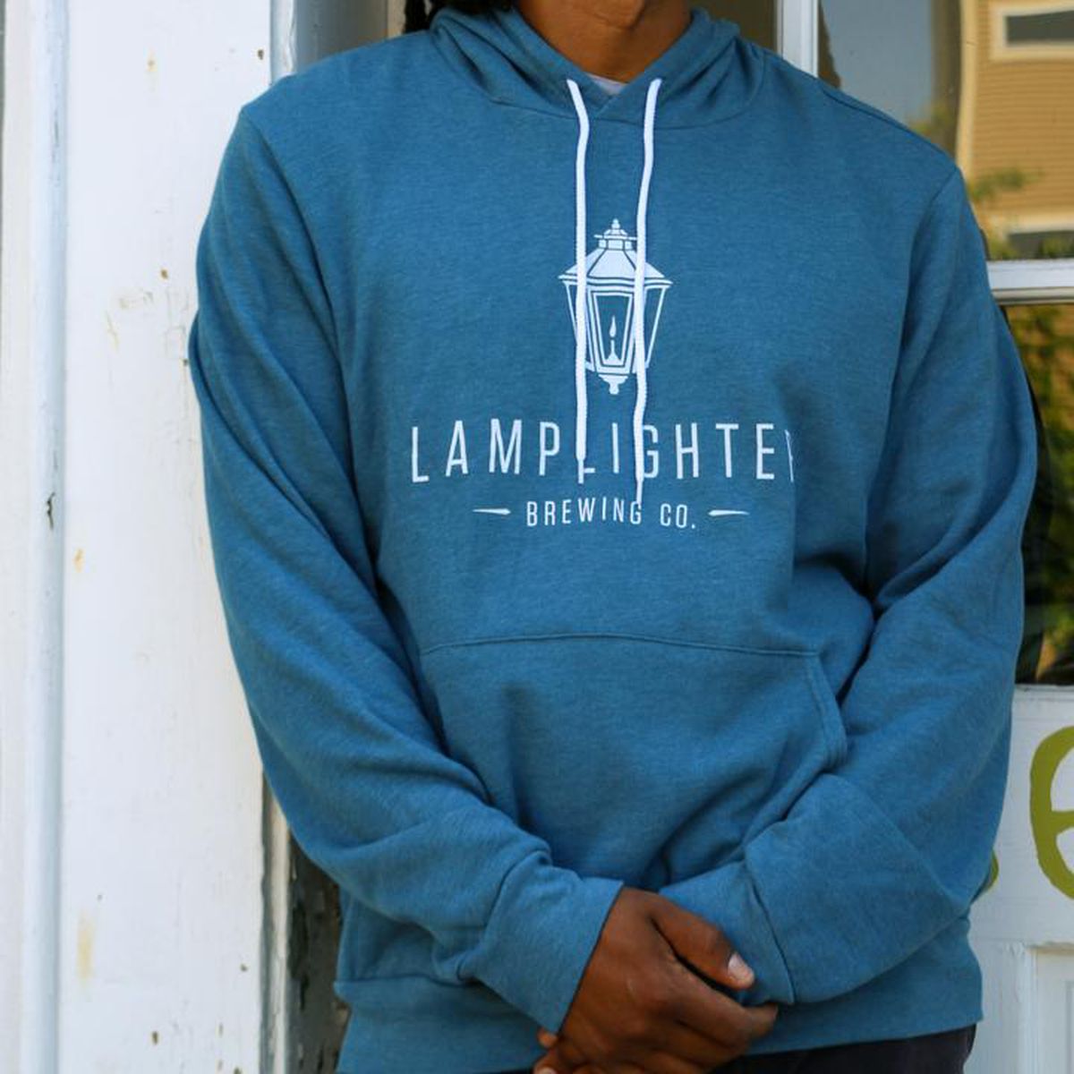 Light blue, almost turquoise, standard hoodie with kangaroo pocket and white strings. It features a white logo for Lamplighter Brewing Co., including old-fashioned street lamp imagery.