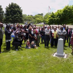 A group of people unveil the new headstone for Hark Lay Wales, who was laid to rest in the Union Pioneer Cemetery in 1887. Until Monday, May 27, 2019, he was buried in an unmarked grave in the Cottonwood Heights cemetery.
