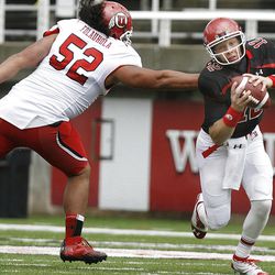 QB Adam Schulz gets away from Moses Folauhola during the Red-White game at Rice-Eccles Stadium at the University of Utah in Salt Lake City on Saturday, April 20, 2013.