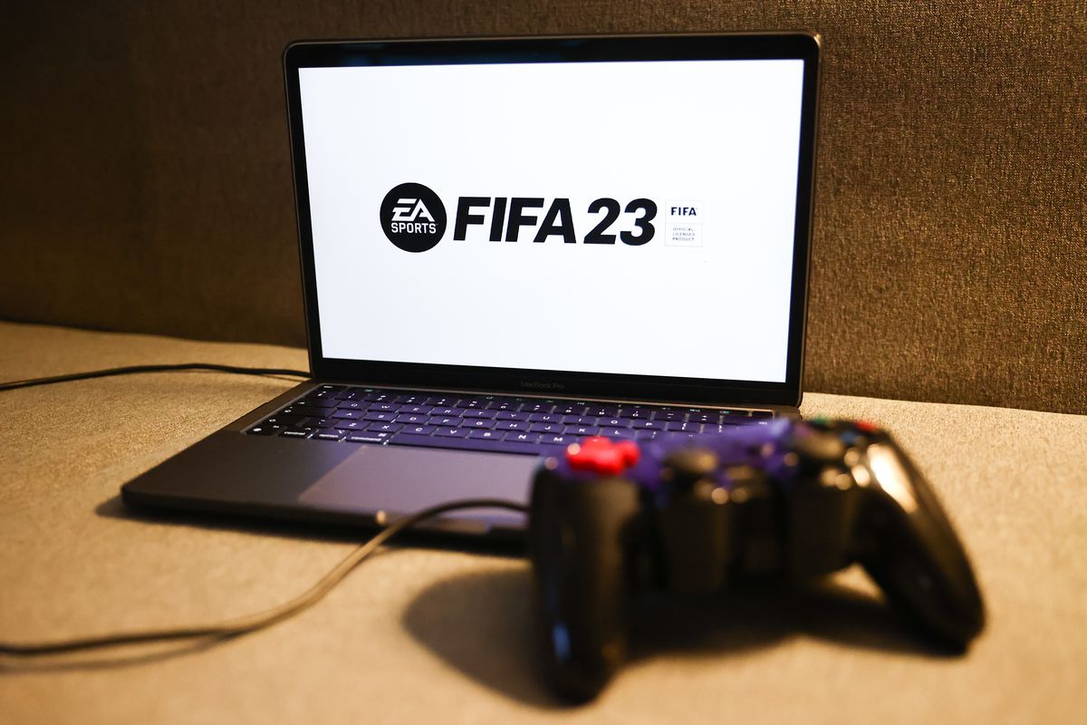 FIFA 23 logo displayed on a laptop screen and a gamepad are seen in this illustration photo taken in Krakow, Poland on August 23, 2022.