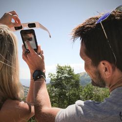 Laurie Ward and Kevin Dunn from Las Vegas take an smartphone photo through their viewers in Park City, Utah.