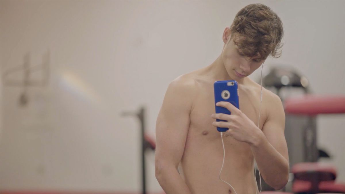 Austyn Tester takes a shirtless selfie in the documentary Jawline.