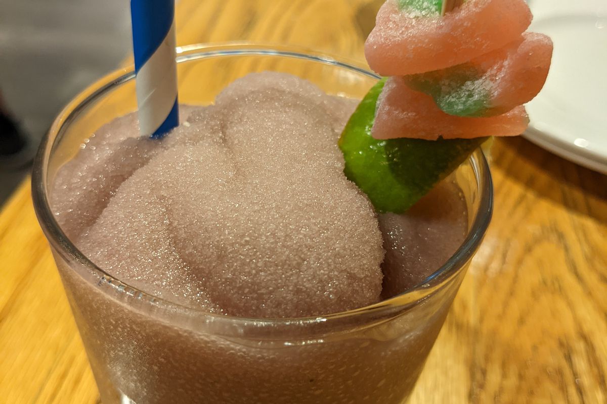 A frozen pink cocktail with watermelon Sour Patch garnishes.