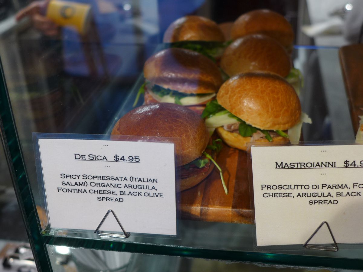 A glass case with tiny round sandwiches.
