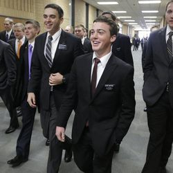 In this Jan. 8, 2013 photo, Mormon missionaries walk through the halls at the Missionary Training Center in Provo, Utah. 